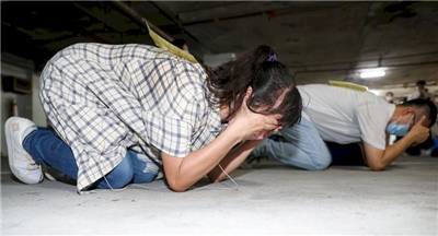 北市萬安演習模擬空襲警報響起，民眾躲至地下避難所後迅速跪倒在地保護身體，將爆炸力衝擊減至最低。資料照片 (圖：中央社)