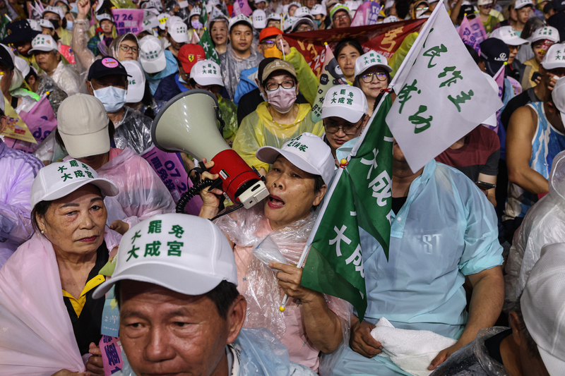首波罷免投票在即，反共護台志工聯盟在25日選前之
夜，舉辦「為民主守夜 公民集氣晚會」，希望催出罷
免同意票，支持者齊聚濟南路，有人帶著大聲公喊聲
造勢。(圖 : 中央社)
