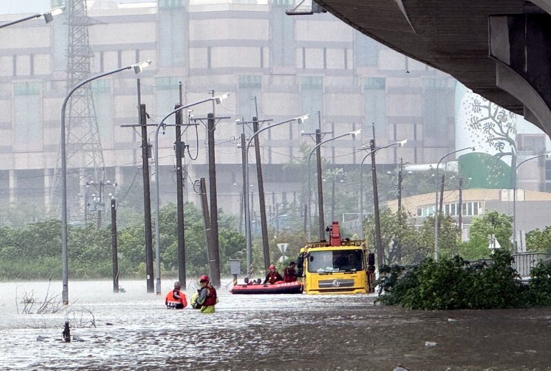 受低壓帶與西南風影響，嘉義縣28日清晨起降大豪雨，消防局獲報，指朴子市台82線下平面道路有一輛台電作業的工程車因嚴重淹水受困，立即派員趕抵，使用救生艇將受困5名台電人員救出。
（嘉義縣消防局提供）