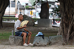20日東半部高溫約攝氏29到32度，背風面的西半部約33至35度。圖為戶外民眾準備扇子搧風降溫。資料照。
