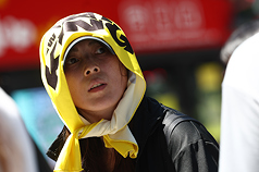 連日高溫，圖為新北市新莊區外出民眾以毛巾遮陽。(中央社資料照片)

