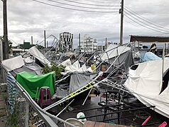 颱風丹娜絲6日深夜在嘉義布袋登陸，嘉義市經1個多小時強陣風肆虐，7日市區街景滿目瘡痍，湖美商展許多攤位扭曲變形、幾乎全毀。
