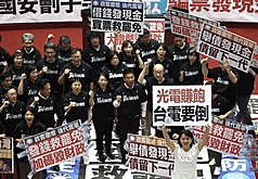 立法院日前三讀通過國民黨提出的特別條例，其中包含「普發現金」新台幣1萬元。圖為三讀後，朝野立委各自在議場內舉牌表達不同立場。