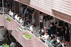 114學年度分科測驗12日舉行第2天考試。圖為考生在考場外進行考前重點複習。