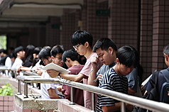 114學年度分科測驗12日舉行第2天考試。圖為考生在考場外進行考前重點複習。