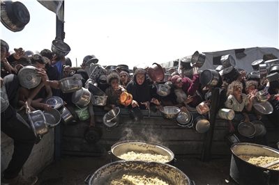 巴勒斯坦民眾在加薩走廊南部一處社區廚房努力獲取捐贈的食物，攝於2025年5月9日。
