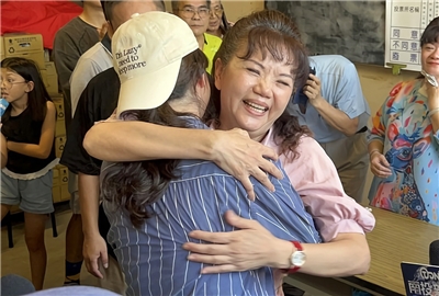 民進黨籍南投縣議員陳玉鈴（中後粉衣者）罷免案13日投開票，罷免團體傍晚5時許自行宣布罷免案不通 過，陳玉鈴則是難掩開心神情，與支持者相擁致意。