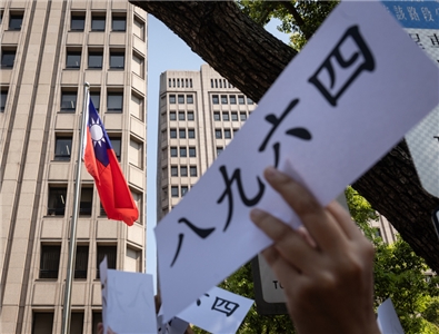 六四被某些政客符號化、工具化：僅成為對「中共模式」的道德譴責標靶，卻不再指向本國及內部社會自身的壓迫。圖為民眾手舉「八九六四」標語。(圖：中央社)