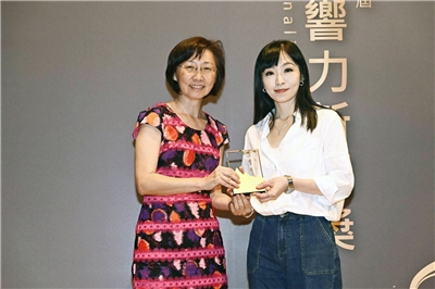 央廣記者劉品希(右)關於外籍看護新制的報導獲「銀響力新聞獎」優選。左為頒獎者輔大社工系副教授王潔媛。(弘道老人福利基金會提供)