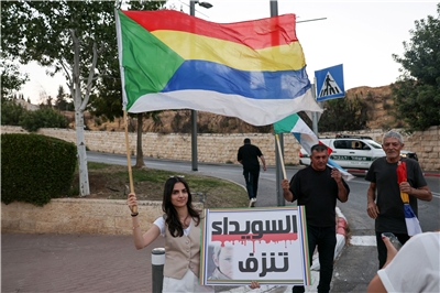 以色列德魯茲人及其支持者在美國駐耶路撒冷大使館附近揮舞德魯茲旗幟並舉起標語牌，以示對鄰國敘利亞德魯茲人的支持。(AFP)