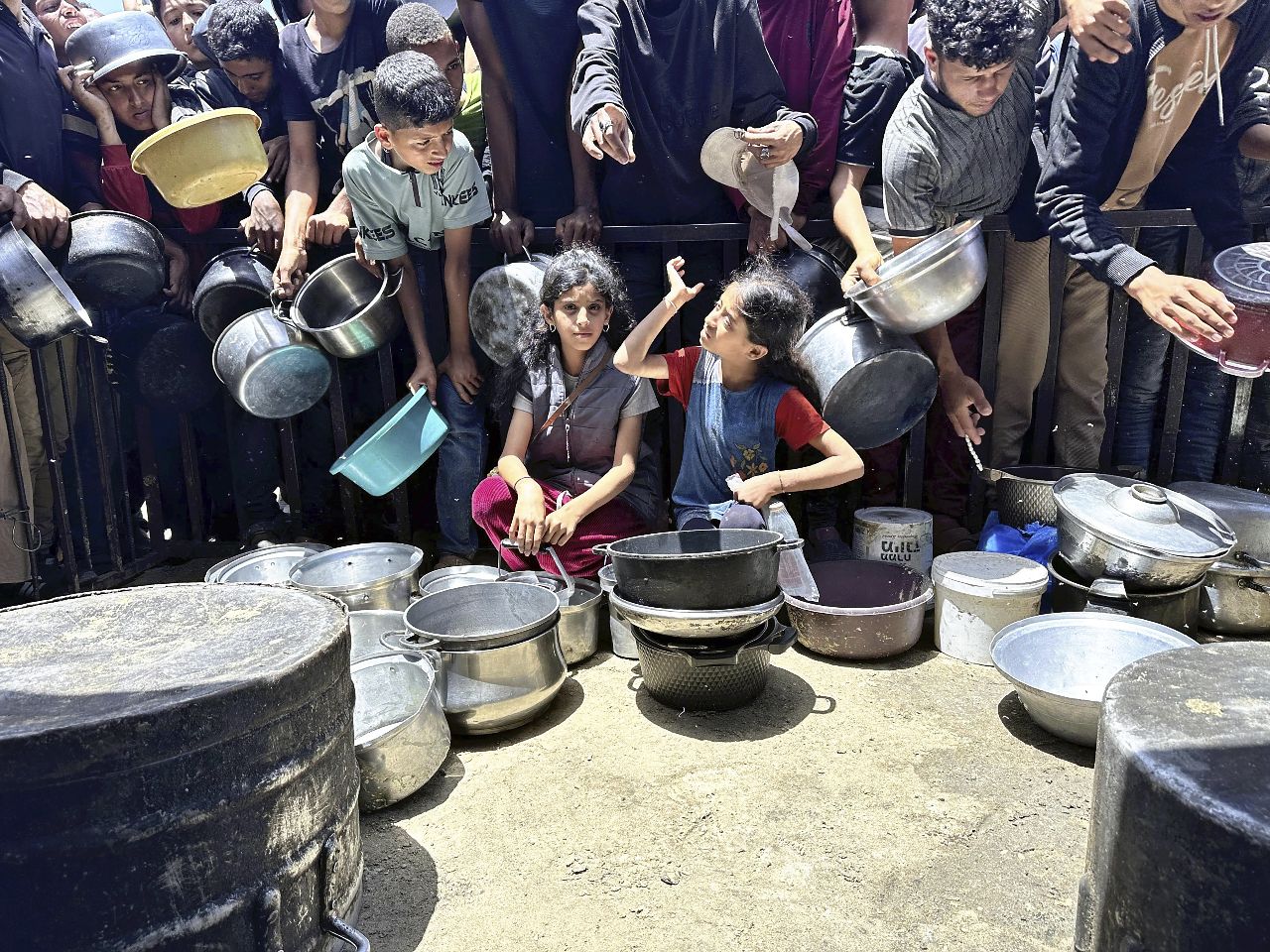 在加薩的汗尤尼斯(Khan Yunis)，居民帶著鍋子和器皿湧入食物配給區。(美聯社/達志影像)