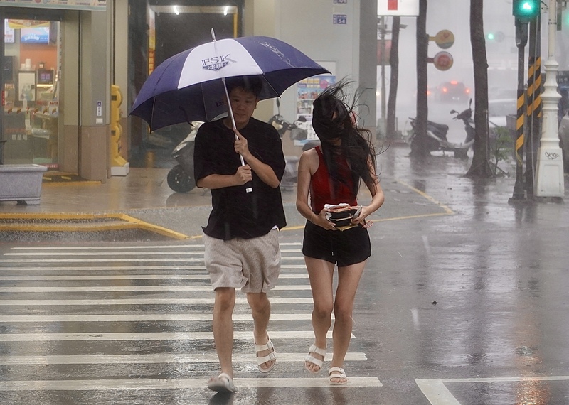 圖為颱風楊柳襲台，高雄地區13日午後風雨轉強，民眾走在苓雅區街頭時，一度被強風吹亂了頭髮。

