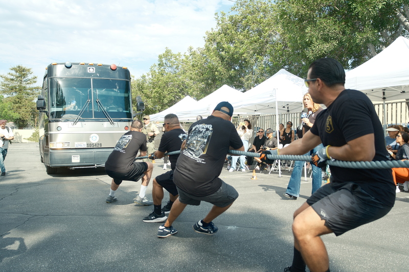 年初受野火重創的洛杉磯郡艾塔迪那(Altadena)警局與民間組織舉行募款活動，警消人員下場，徒手拉
動22公噸的警用巴士。