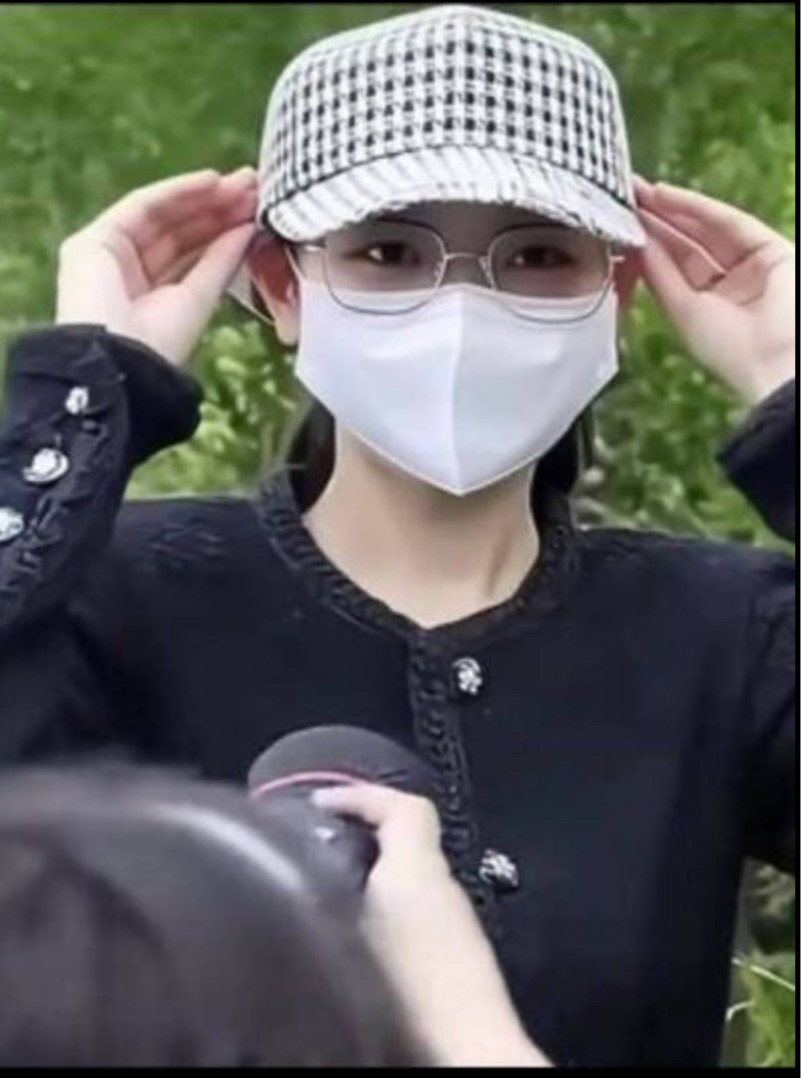 楊蘭蘭在保鏢陪同下前往當地警局。面對記者詢問，楊蘭蘭低頭掩面不回應。(照片取自網路)