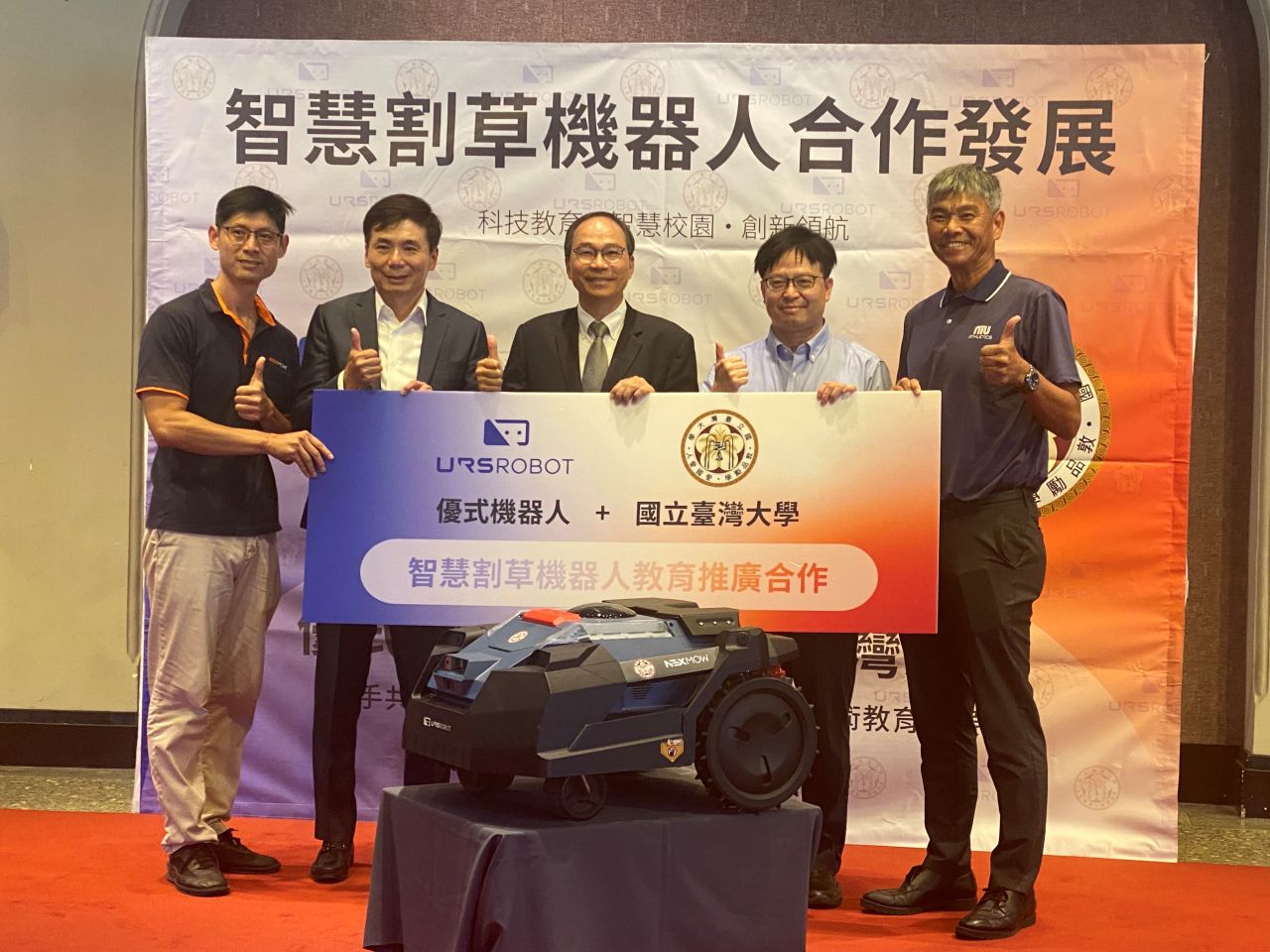 台大體育室、台大機械工程系與優式機器人公司25日在台大副校長丁詩同(中)見證下，首度對外展示雙方與台大體育室合作的第一代「智慧割草機器人」。(吳琍君 攝)