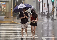圖為颱風楊柳襲台，高雄地區13日午後風雨轉強，民眾走在苓雅區街頭時，一度被強風吹亂了頭髮。
