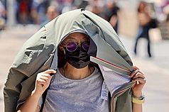 全台週末高溫炎熱，圖為台北車站前民眾防曬一景。

