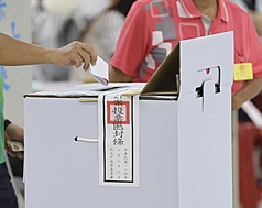 圖為民眾將摺好的票投進票匭。
