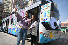甘肅蘭州公交集團推出外型吸睛的文創主題巴士，車廂內展示多種文創產品。圖為5月8日，民眾與文創主題巴士自拍。