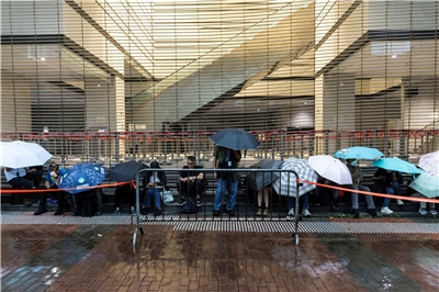 香港壹傳媒集團創辦人黎智英被控勾結外國勢力的國安案，原定今天(14日)起在法院進行結案陳詞，許多民眾不畏風雨前往聆聽，但最後因天候惡劣而宣布延後。(AFP)