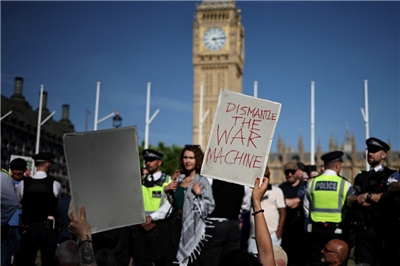 在倫敦市中心的國會廣場，示威者手持標語牌，支持被禁組織「巴勒斯坦行動」（Palestine Action），要求解除最近實施的禁令。