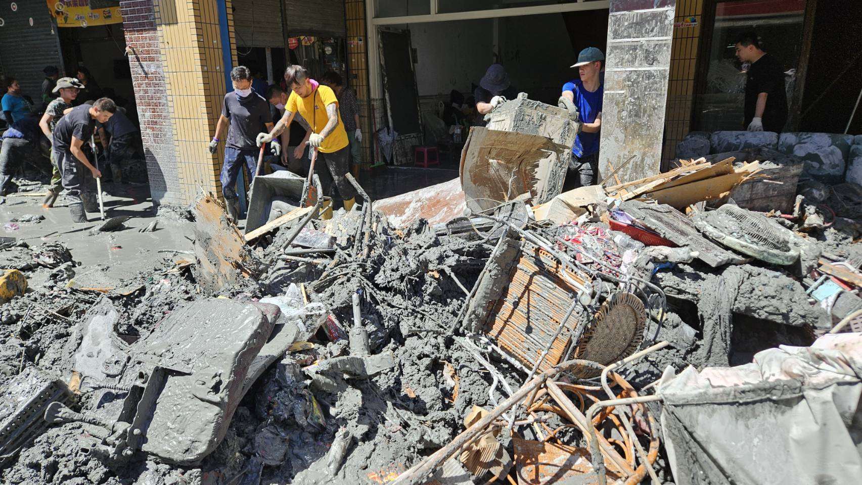 花蓮光復鄉受災戶9月、10月電費全免。圖為居民忙著清掃家園，廢棄、物泥濘全都堆在馬路上。(歐陽夢萍 攝)