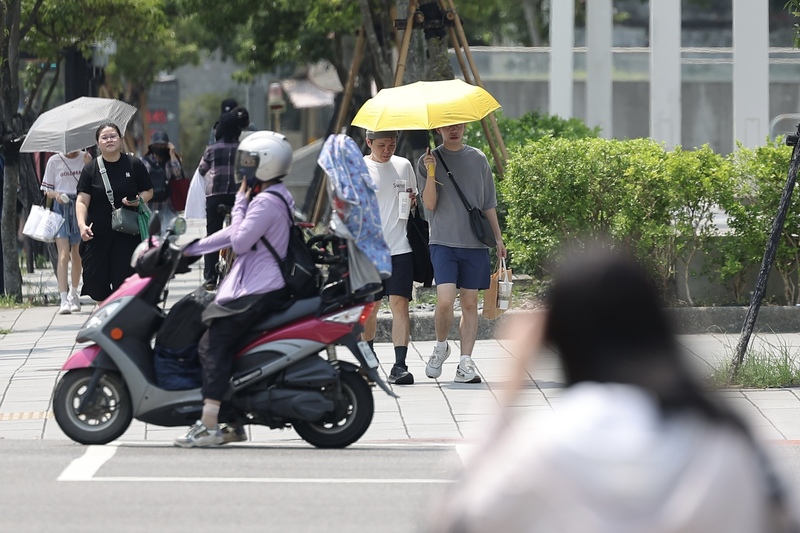 各地近日高溫炎熱，根據氣象署資料，中午12時新北五股高溫已達38.8度。圖為北市民眾外出防曬。