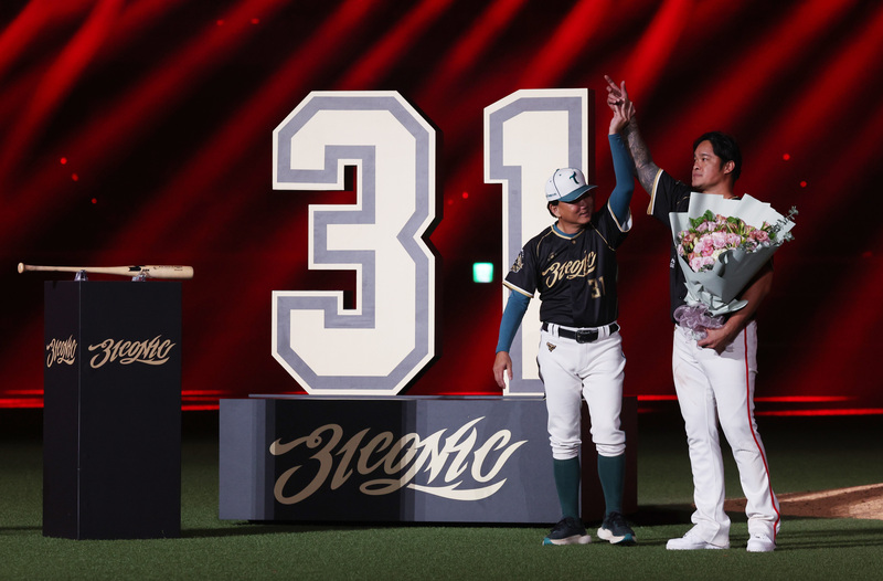 中華職棒味全龍隊「大師兄」林智勝（右）7日在台北大巨蛋舉行引退賽，林智勝在Lamigo桃猿時期的總教練洪一中（左）留到引退儀式、獻上花束，並一同向球迷致意。
