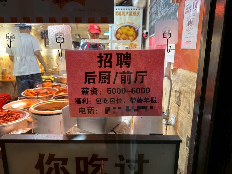 中國自9月1日起實施強制社保，學者表示，這將使僱傭成本大幅提升，中小企業、低薪勞工將首當其衝。圖為上海一間餐館的徵才文宣，該店員工表示沒有社保，攝於8月30日。