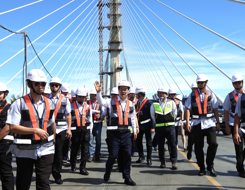 總統賴清德（前中，揮手者）16日上午出席淡江大橋合龍典禮，並向與會者揮手致意。