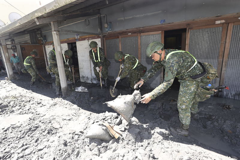 花蓮馬太鞍溪堰塞湖23日溢流造成嚴重災情，圖為25日國軍官兵在光復鄉協助居民清除家門前的淤泥。


