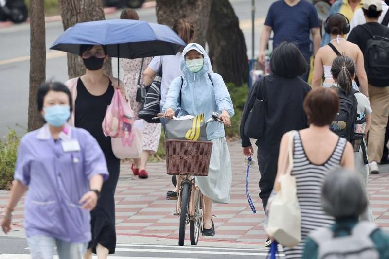 圖為台北市中正區街頭民眾全身包緊緊防曬。資料照。