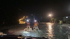 花蓮馬太鞍溪堰塞湖溢流，洪水沖斷橋梁，光復鄉部分地區淹水災情嚴重，台東縣消防局支援搶救，揹著災民徒步跨越泥水撤離至收容所。（台東縣消防局提供）

