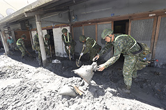 花蓮馬太鞍溪堰塞湖23日溢流造成嚴重災情，圖為25日國軍官兵在光復鄉協助居民清除家門前的淤泥。


