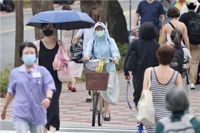 圖為台北市中正區街頭民眾全身包緊緊防曬。資料照。
