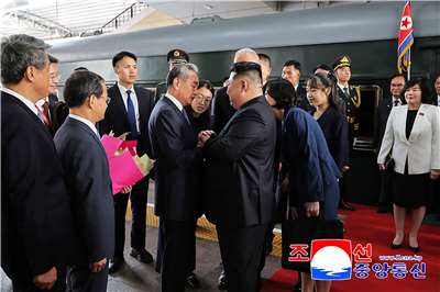北韓最高領導人金正恩(中) 1日在火車站接受中國外長王毅的迎接，他身後站著據信是他的女兒金朱愛（Kim Ju-ae，音譯）(右四)。