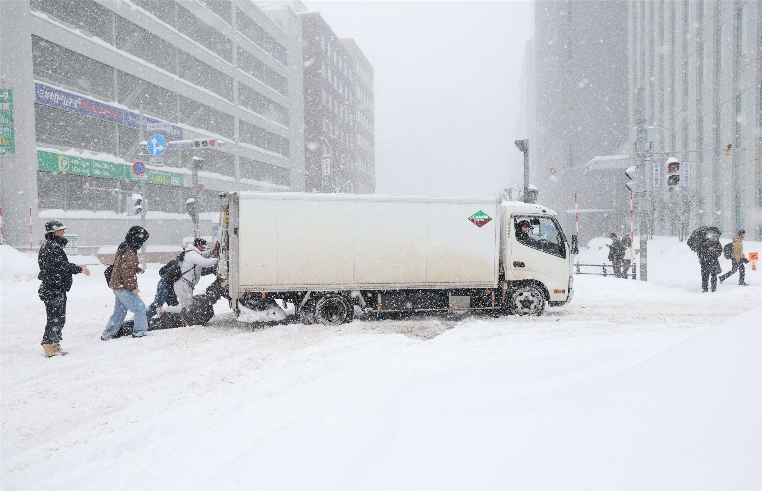 日本近日受到強烈寒流影響，各地積雪量大幅超過往年水準，北海道地區因短時間大量積雪導致交通狀況連連。(AFP)