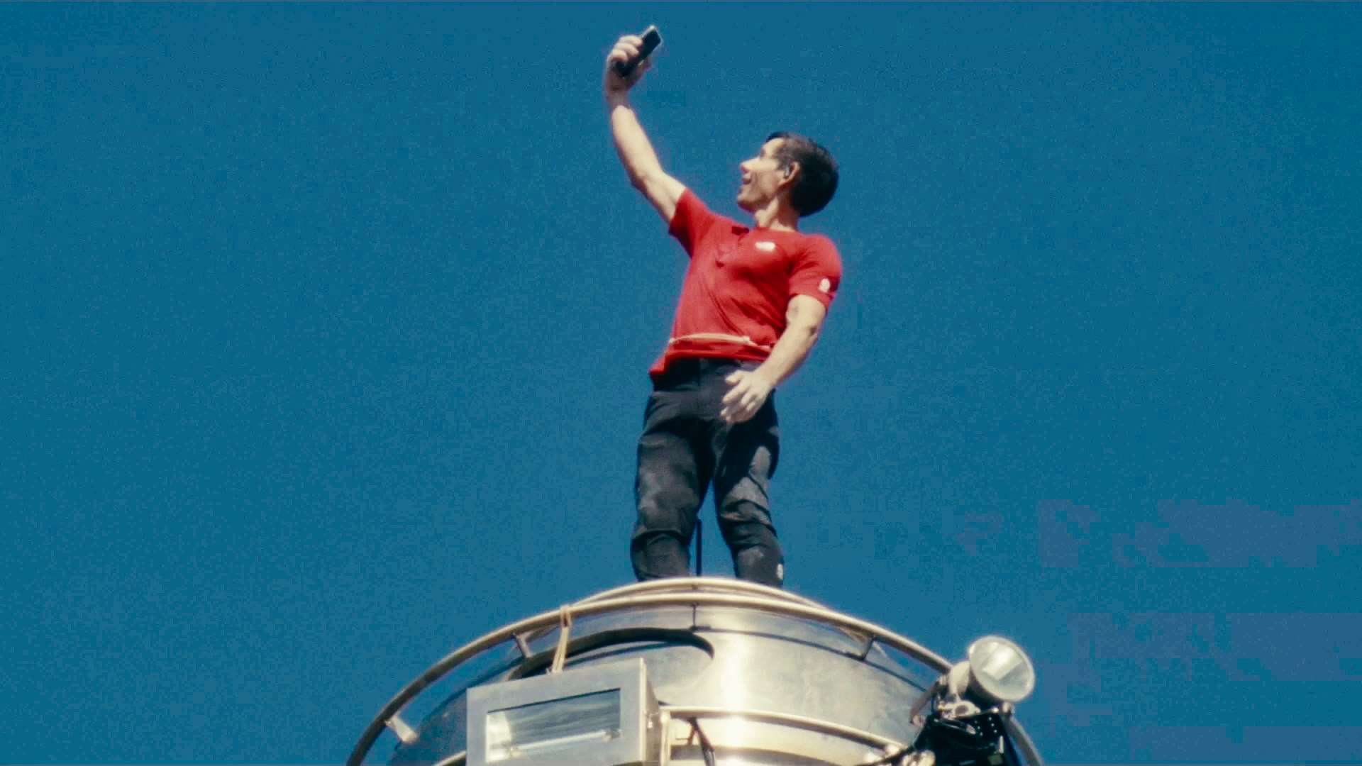 美國攀岩傳奇霍諾德25日順利完成徒手攀登台北101。當霍諾德登上101最頂的509.2公尺高塔尖時，他特別拿出手機自拍並享受壯闊風景。(圖：Netflix提供)