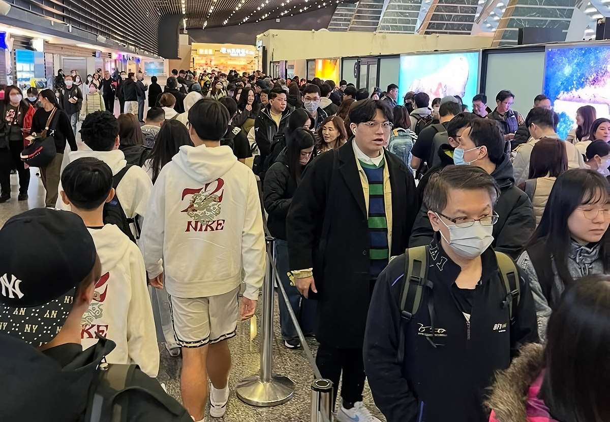 寒假正式開跑，桃園國際機場24日上午湧現出國人潮，但部分航空公司傳出全球劃位系統短暫異常，影響旅客報到以及行李託運作業，機場一度大排長龍。(網友doubleblack_8636提供/圖：中央社)