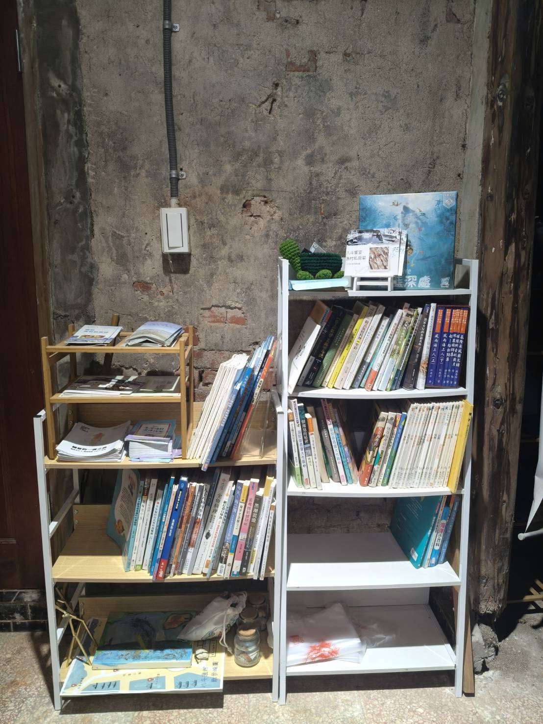 海洋大學學生游千慧所設計的「大坪海岸遊程導覽地圖手冊」，放置在當地的索取點(書架的左上方)。(圖：游千慧同學提供)