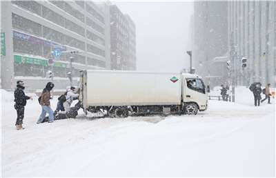 日本近日受到強烈寒流影響，各地積雪量大幅超過往年水準，北海道地區因短時間大量積雪導致交通狀況連連。(AFP)