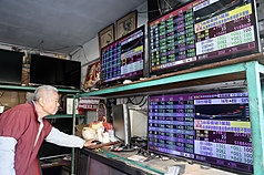 台股6日早盤一度上揚逾百點，來到30217點。圖為萬華區商家觀看台股走勢。資料照片。