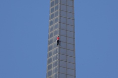 美國攀岩好手霍諾德（Alex Honnold）（紅衣）25日挑戰徒手獨攀台北101，霍諾德爬行速度相當快速，1
小時多的時間就已接近攻頂位置。
