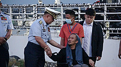 新加坡籍散裝貨船Devon Bay號22日晚間在南海翻覆，部分船員被中國海警船救起，26日返回馬尼拉。菲律賓海岸防衛隊司令加文（前左）26日清晨在馬尼拉碼頭慰問一名生還船員。