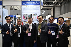 全球奈米科技領域年度盛會「國際奈米科技綜合展與技術會議」28日在東京盛大揭幕，駐日代表李逸洋（左3）參觀國立陽明交通大學參展攤位，由台大醫院急診醫學部主任張維典（右3）介紹發明結合光學微流體導管和光激發奈米藥物，可改善急性心肌梗塞治療效果，節省醫療開支。
