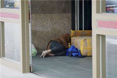 圖為台北車站的街友瑟縮在角落休息避寒。資料照。