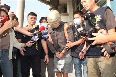 男子梁育誌(中)涉殺害長榮大學馬來西亞籍女大生案，更二審從死刑改判無期。圖為先前面對媒體詢問，梁育誌低頭不發一語。資料照。(圖：中央社)