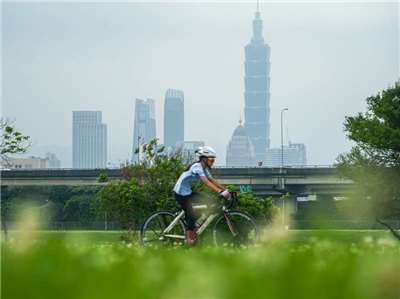 環境部28日公布最新版空氣污染排放清冊，統計結果顯示我國2023年主要空氣污染物排放總量較2021年減少近12%。圖為民眾前往台北市中山區河濱公園騎車運動。(圖：中央社)