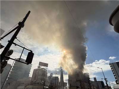 大阪知名地標通天閣附近一棟大樓今天上午發生大火，濃密黑煙直衝天際。(X平台/@lzinjapan)
