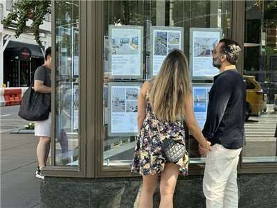 圖為美國民眾在看房屋銷售廣告。 (圖：中央社檔案照)